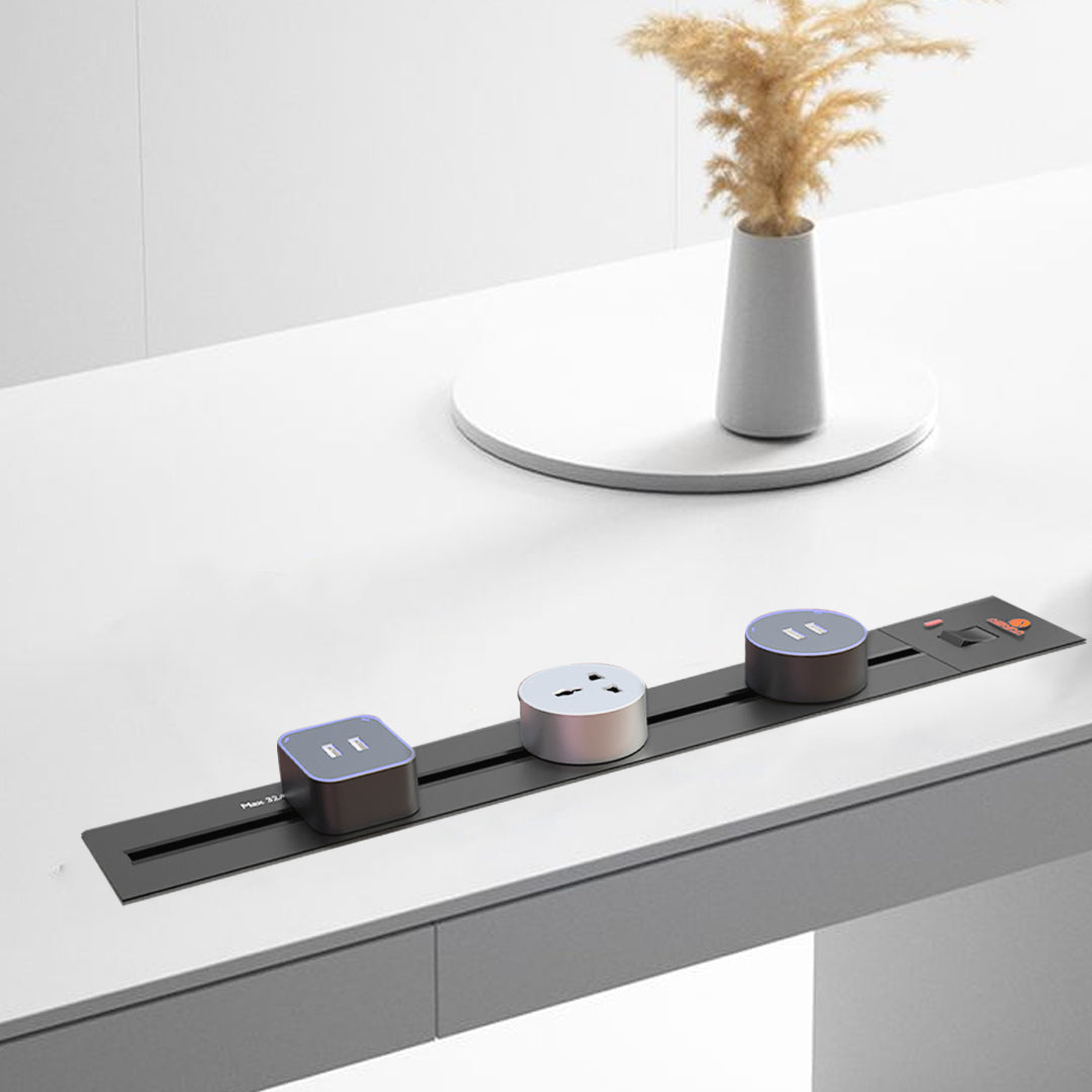 Silver surface-mounted Adivaa Power Track with sockets along a white desk