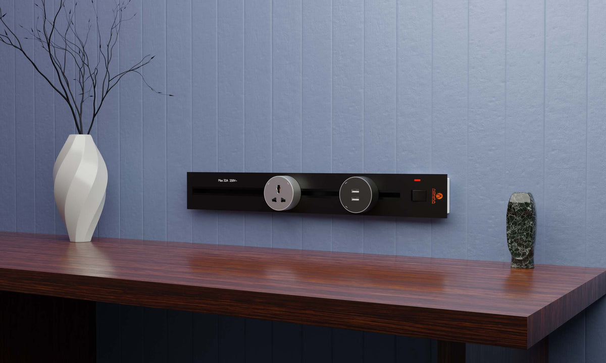 Surface-mounted power track with sockets on the wall behind a desk