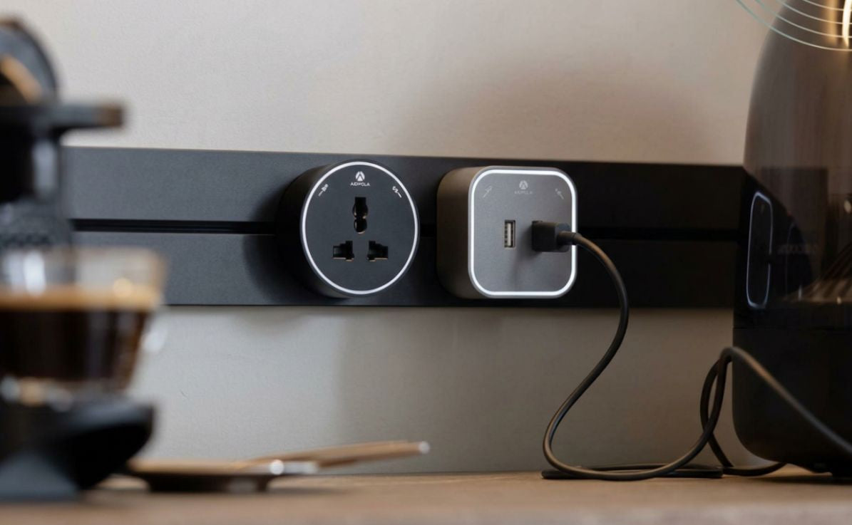 Close-up of an Adivaa socket and USB charging module on a track with a cable plugged in